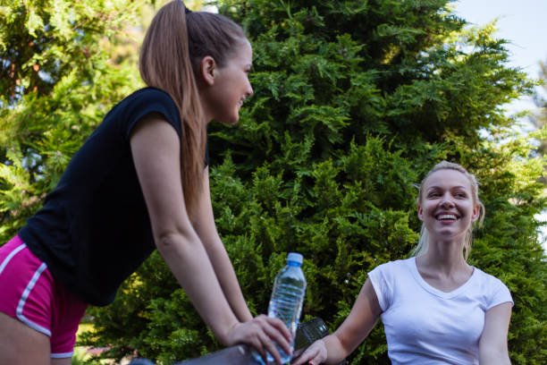 istock Two sporty women resting on bench 1165062260