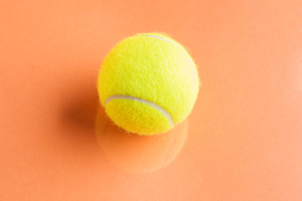 istock Tennis ball on orange abstract background 1165062320