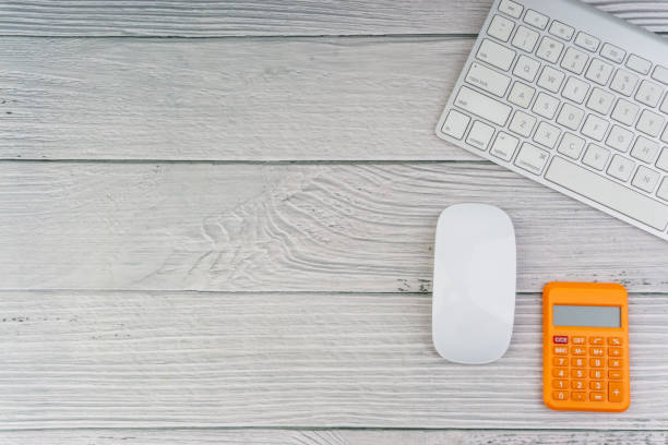 istock Workspace with mouse, calculator and keyboard on the wooden background 1165063438