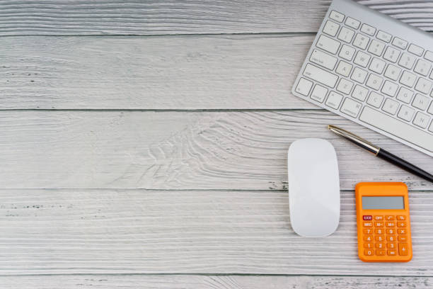 istock Workspace with mouse, pen, calculator and keyboard on the wooden background 1165063440