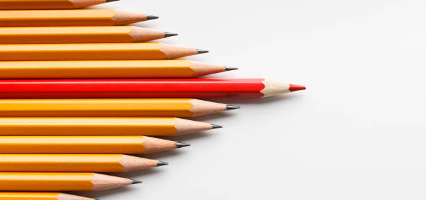 Red pencil leading another similar ones, influencing the crowd Opinion leadership concept. Red pencil leading another similar ones, influencing the crowd, white panorama background with free space protruding stock pictures, royalty-free photos & images