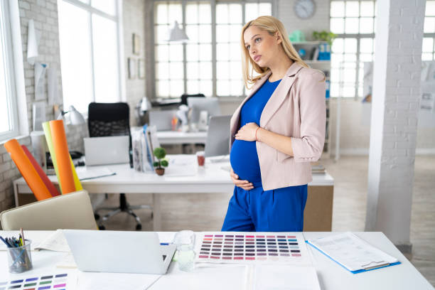 istock Pregnant woman drinking water at workplace 1165066094