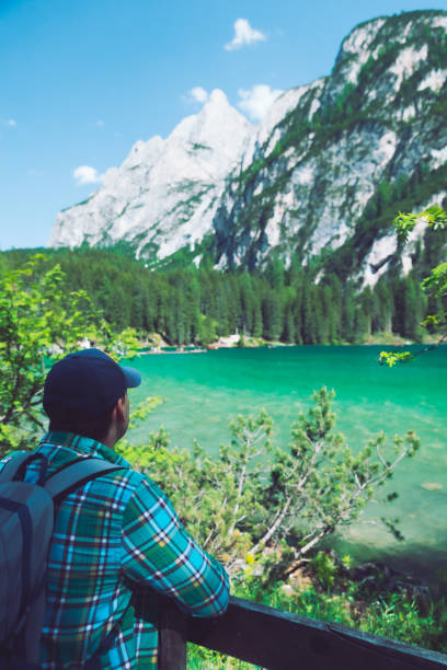istock man with backpack looking at lake in dolomites mountains 1165066146