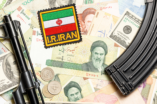 Soviet automaton AK 47 against the backdrop of Iranian money depicting Ruhollah Khomeini and Iranian flag