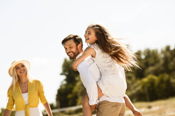 istock Father piggybacking his daughter, walking and resting outside 1165070336