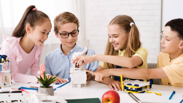 istock Stem education. Schoolchildren with diy robot, panorama 1165070383
