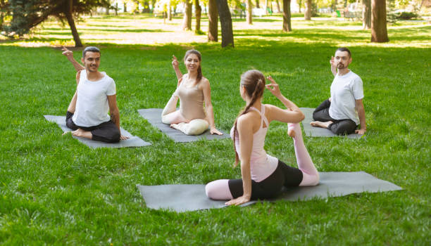 istock Friends having lesson with yoga instructor, sitting in Mermaid exercise 1165071495