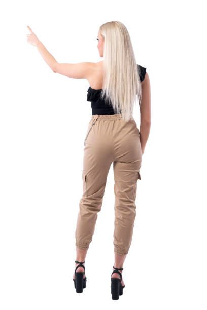 istock Back view of blonde young stylish woman shopper choosing and pointing finger up. 1165073473
