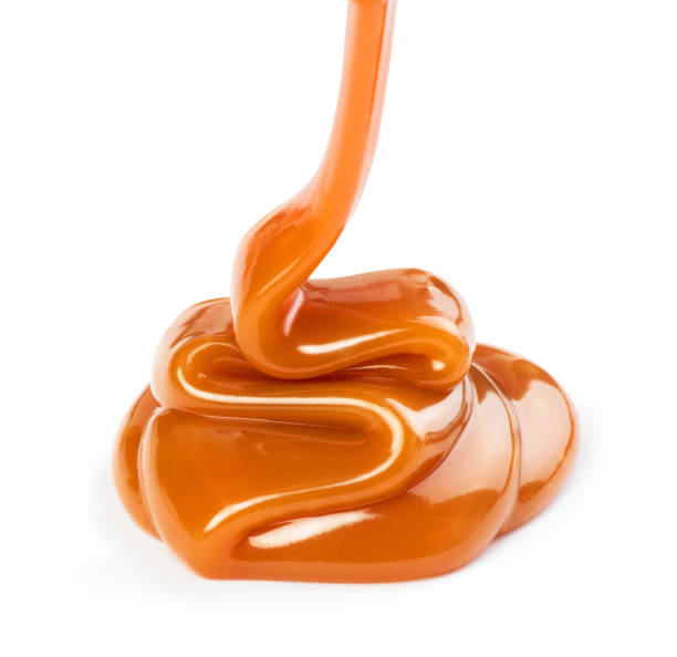 istock Pouring sweet caramel sauce on white background 1165074939