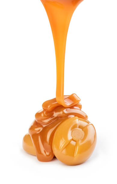 istock Delicious caramel sauce pouring on white background 1165074988