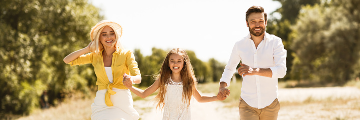 Happy family running together in countryside, resting and having picnic, panorama