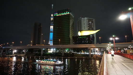 Tokyo / Japan - Sept 15 2018: View Tokyo Skytree, Sumida River at night. The modern architectures of the Asahi Super Dry Mall