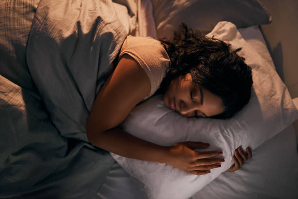 Still stuck in dream land High angle shot of a beautiful young woman sleeping in her bed at home during the night Pillow stock pictures, royalty-free photos & images