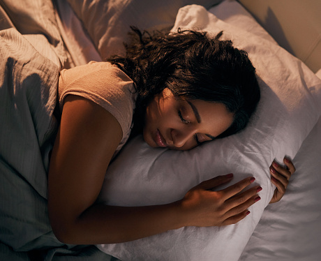 High angle shot of a beautiful young woman sleeping in her bed at home during the night