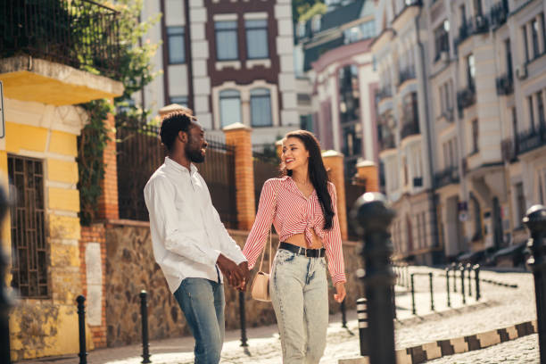 istock Joyful couple holding hands and strolling 1165075957