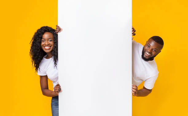 pareja africana posando con tablero blanco vacío - marketing commercial sign african descent african ethnicity fotografías e imágenes de stock