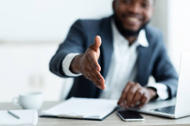 African American businessman extending hand to shake Partnership concept. Smiling young African American businessman extending hand to shake. african american business couple stock pictures, royalty-free photos & images