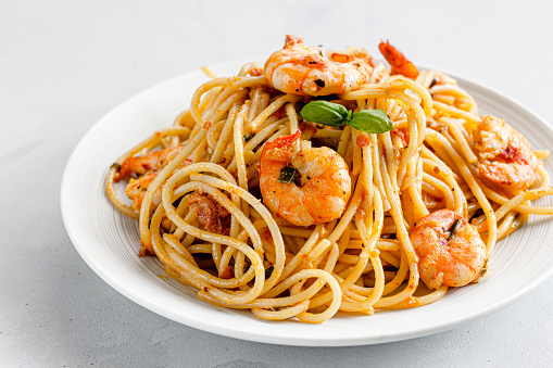 Shrimp Spaghetti Pasta on a White Plate and on White Background. Close-Up Photo of Shrimp / Prawn Pasta, Italian Food Photography.