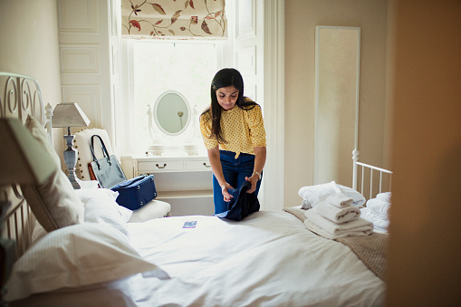 Woman unpacking in a hotel room while away on a business trip.