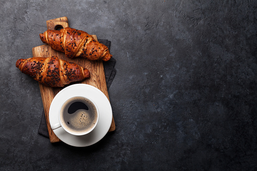 Coffee and croissant on stone table. French breakfast. Top view flat lay with copy space for your text