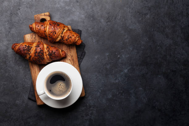 Coffee and croissant Coffee and croissant on stone table. French breakfast. Top view flat lay with copy space for your text baked pastry item stock pictures, royalty-free photos & images