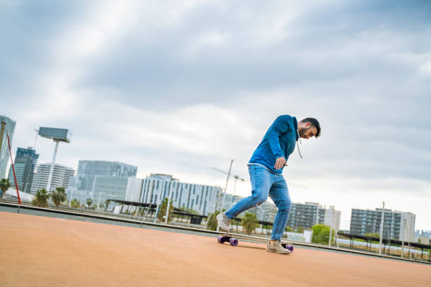 istock Longboard skating with Barcelona skyline at background 1165085956