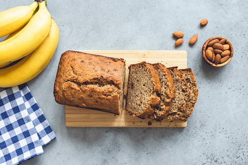 Banana bread with nuts sliced on concrete table background. Table top view