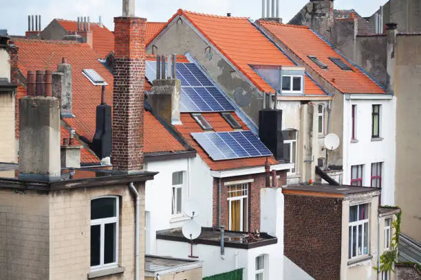 Roofs and backside of houses in Brussels, one with solar panels. Houses in Brussels Schaerbeek.