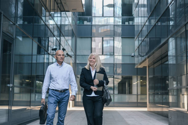istock Two colleague talking after work in front of their office building 1165094913