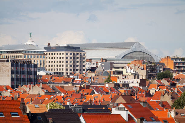 Brussels, Belgium;June,08.2024: Along the street, between the facades of the houses, in the distance, you can see the tower of the Brussels City Museum