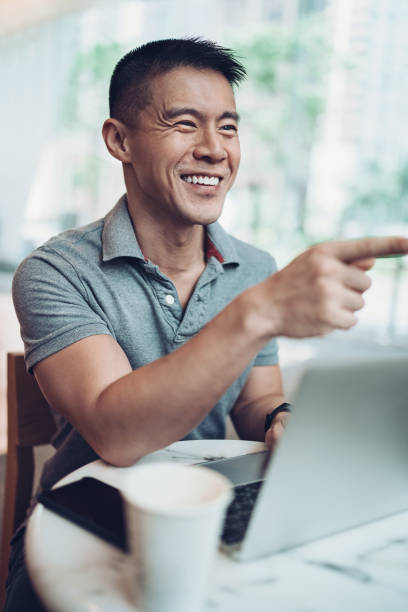istock Smiling man with laptop in a restaurant 1165097150