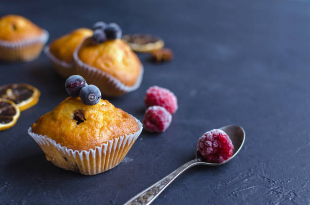 istock Sweet muffins with berries on dark textured background. 1165097358