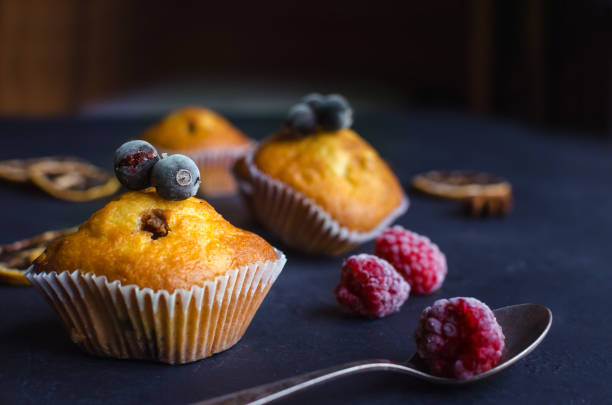 istock Sweet muffins with berries on dark textured background. 1165097359
