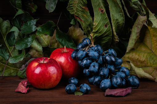 apples and grapes on a background of autumn leaves