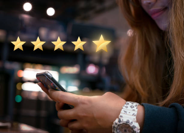 Millennial woman submitting star rating feedback on mobile device after internet shopping experience Woman internet shopping on smartphone submitting 5 gold star satisfaction feedback - Millennial girl reply to customer experience survey questions by email - Review, success & retention concept Happy Customer stock pictures, royalty-free photos & images