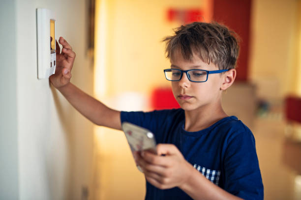 Little boy pairing smartphone with smart home system