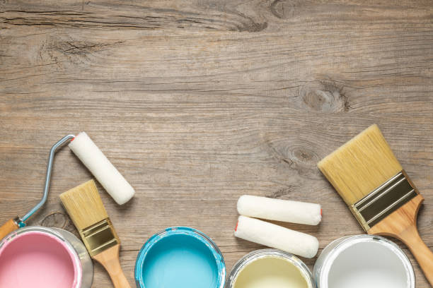istock Paint brush and cans on wooden table 1165100076
