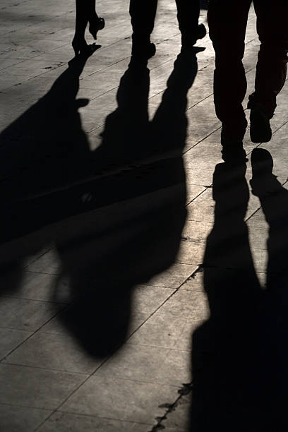 istock sun casting shadow over three people walking on the street 116510119