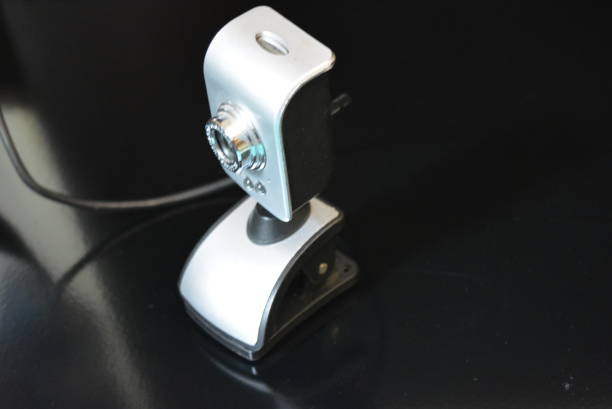 istock A silver webcam for the computer with clips for the monitor is located on a black matte surface with reflection. 1165101759
