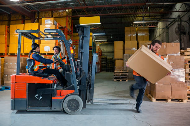 an industrial warehouse workplace safety topic.  a maleemployee injured by tripping over forklift forks. - wrong injury imagens e fotografias de stock