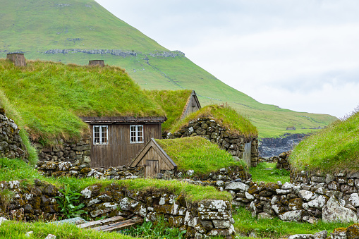 Icelandic turf houses on Heimaey island, made of black rocks on rainy day. Iceland