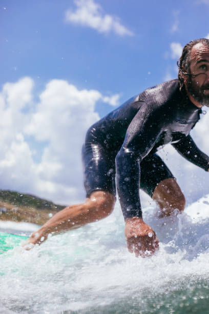 istock Attractive man surfing a wave off the coast 1165103212