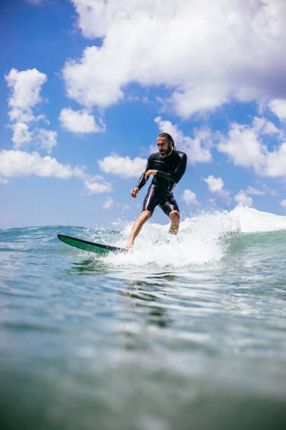 Attractive man surfing a wave off the coast