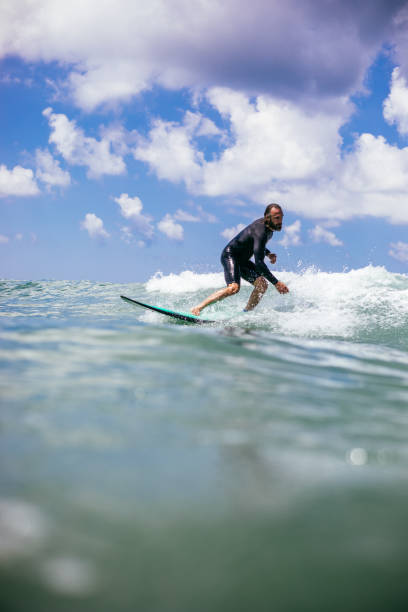 istock Attractive man surfing a wave off the coast 1165103965