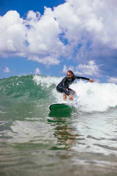 istock Attractive man surfing a wave off the coast 1165104263