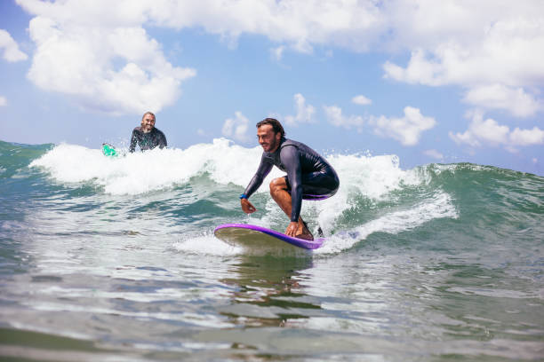 istock Attractive man surfing a wave off the coast 1165104392