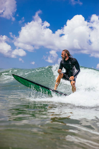 istock Attractive man surfing a wave off the coast 1165104410