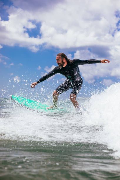 istock Attractive man surfing a wave off the coast 1165104412