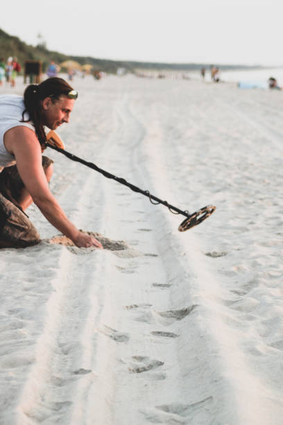 istock Man with metal detector on the beach 1165106016