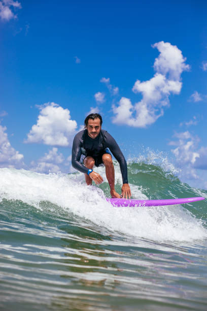 istock Attractive man surfing a wave off the coast 1165106025